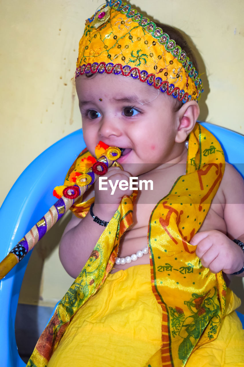 child, childhood, yellow, one person, portrait, clothing, multi colored, looking at camera, toddler, baby, indoors, front view, innocence, traditional clothing, cute, women, person, men, female, waist up, fun, paint, studio shot, lifestyles