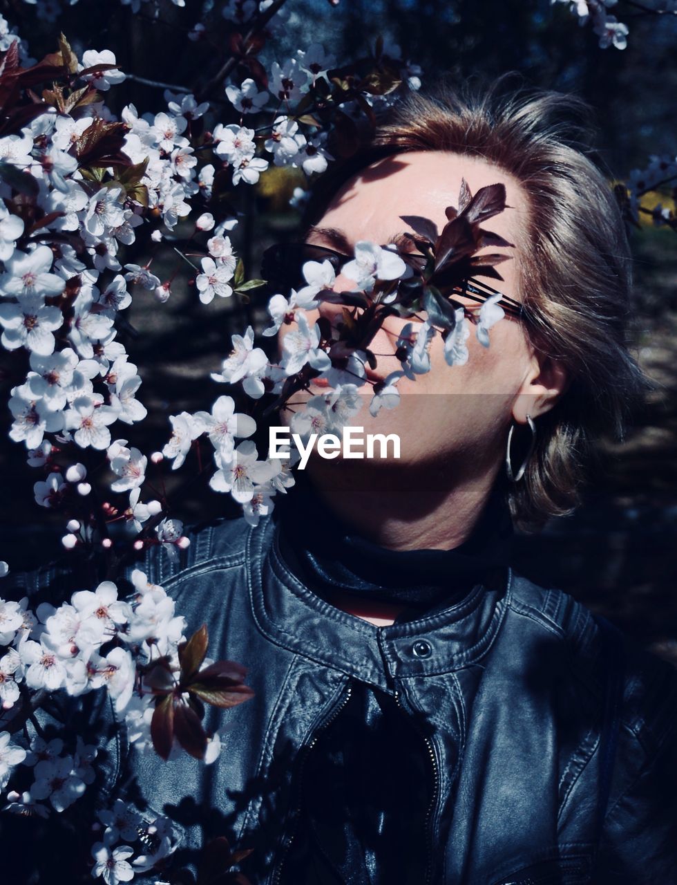 Woman by flowering plants in park