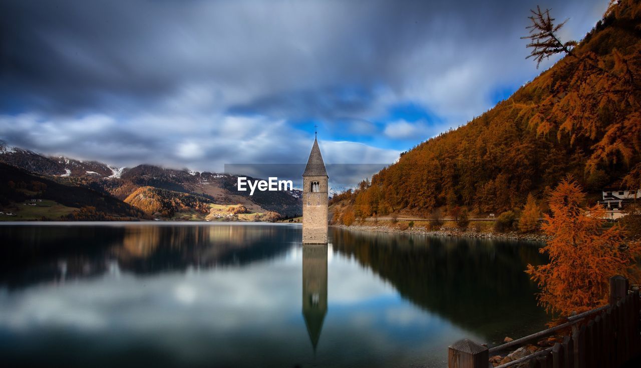 PANORAMIC VIEW OF BUILDINGS BY MOUNTAINS AGAINST SKY