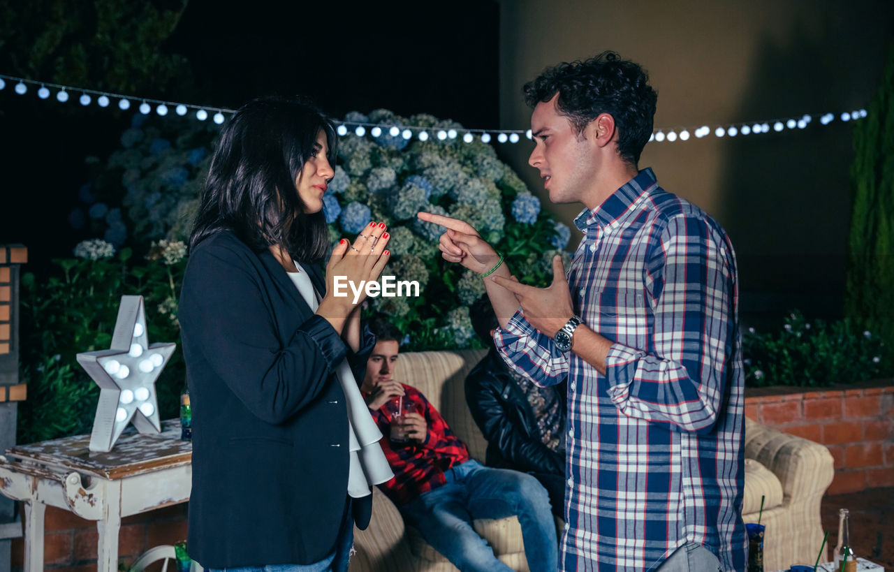 Young friends talking during party in backyard at night