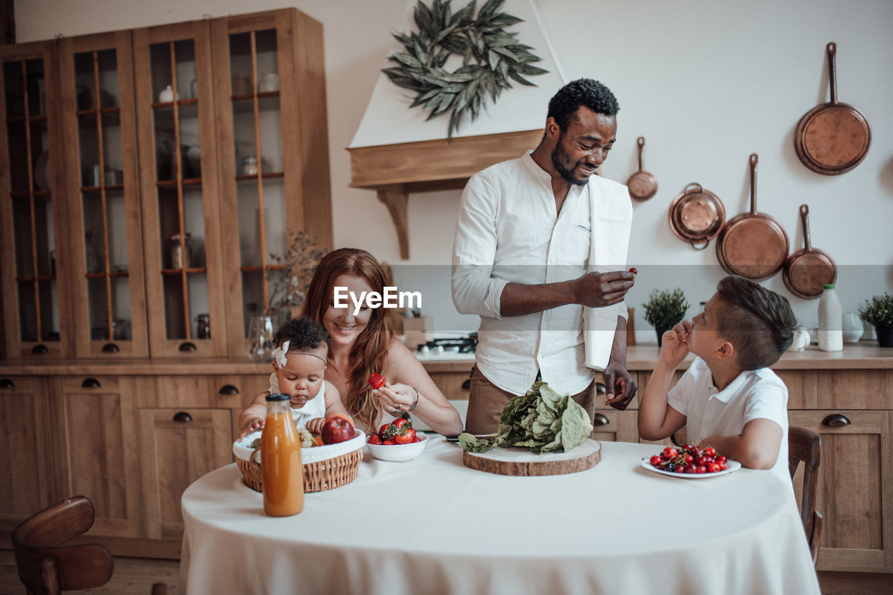 Group of people sitting on table at home