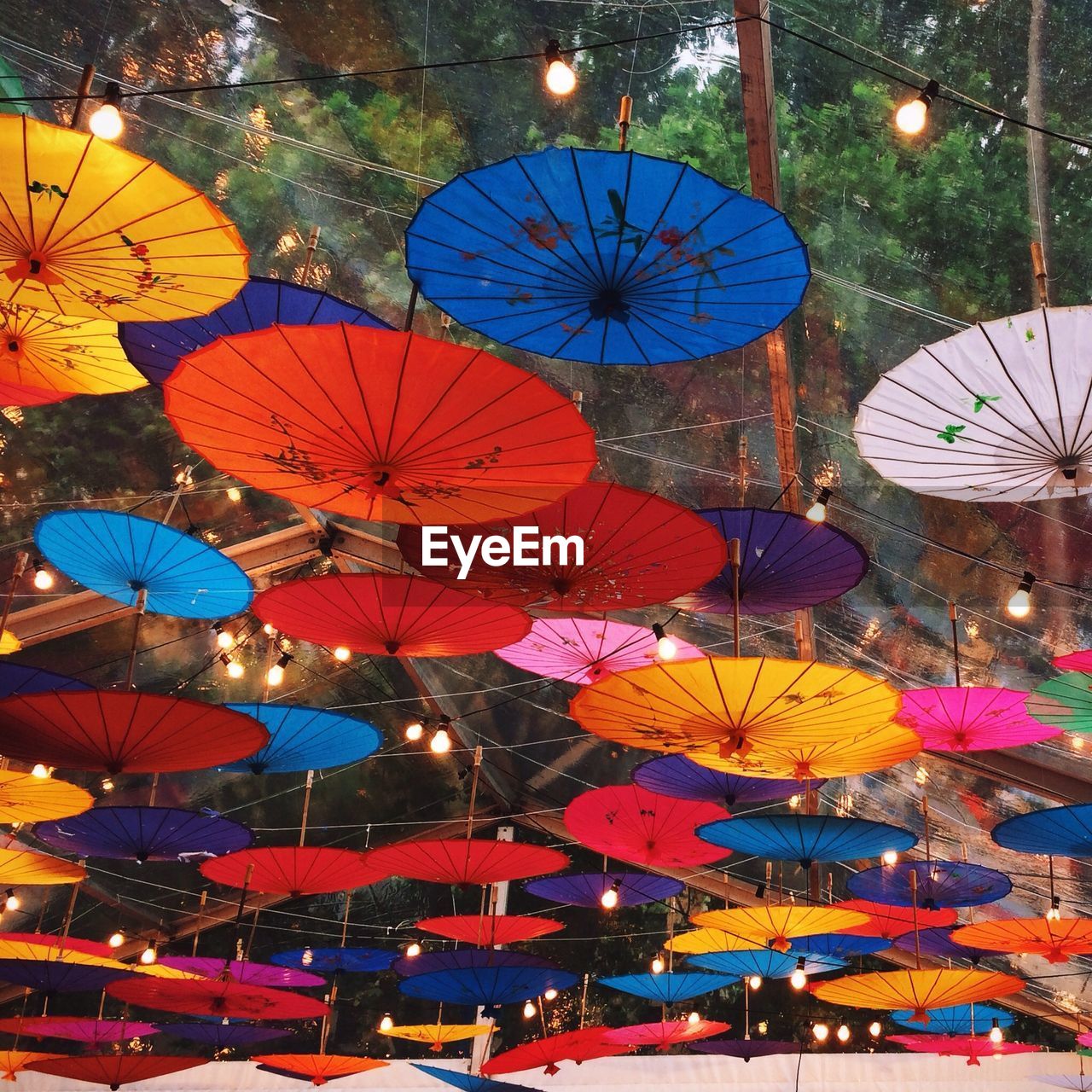 Low angle view of multi colored umbrellas hanging from cables