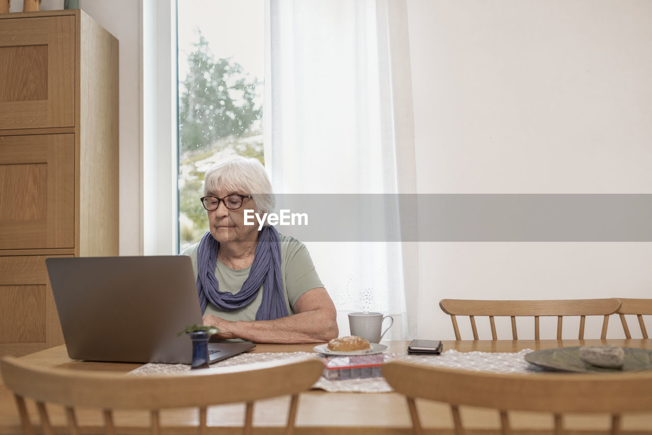 Senior woman using laptop at table