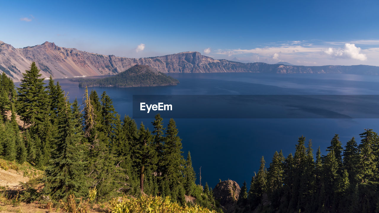 Scenic view of sea and mountains against sky