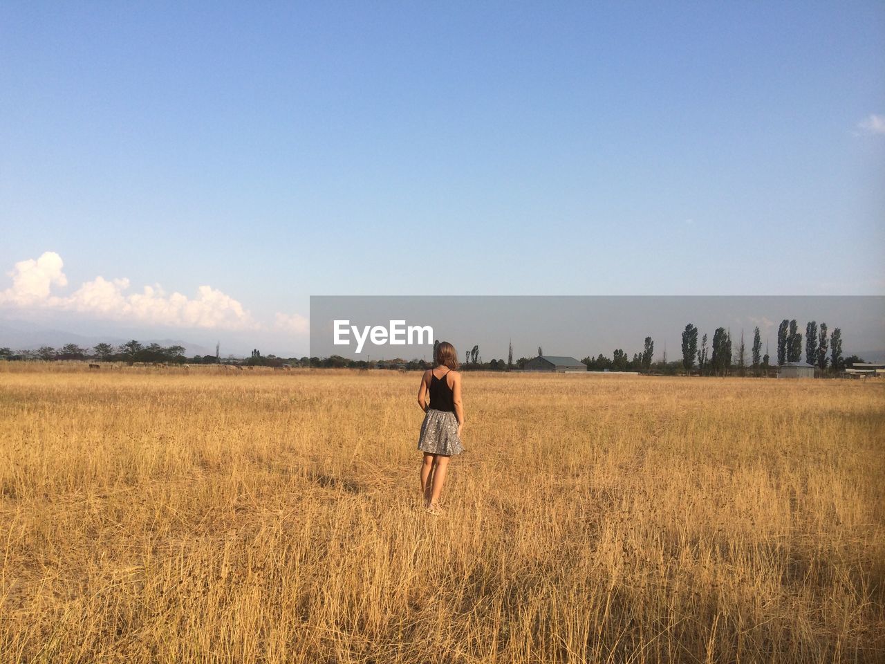 Woman standing on field against sky