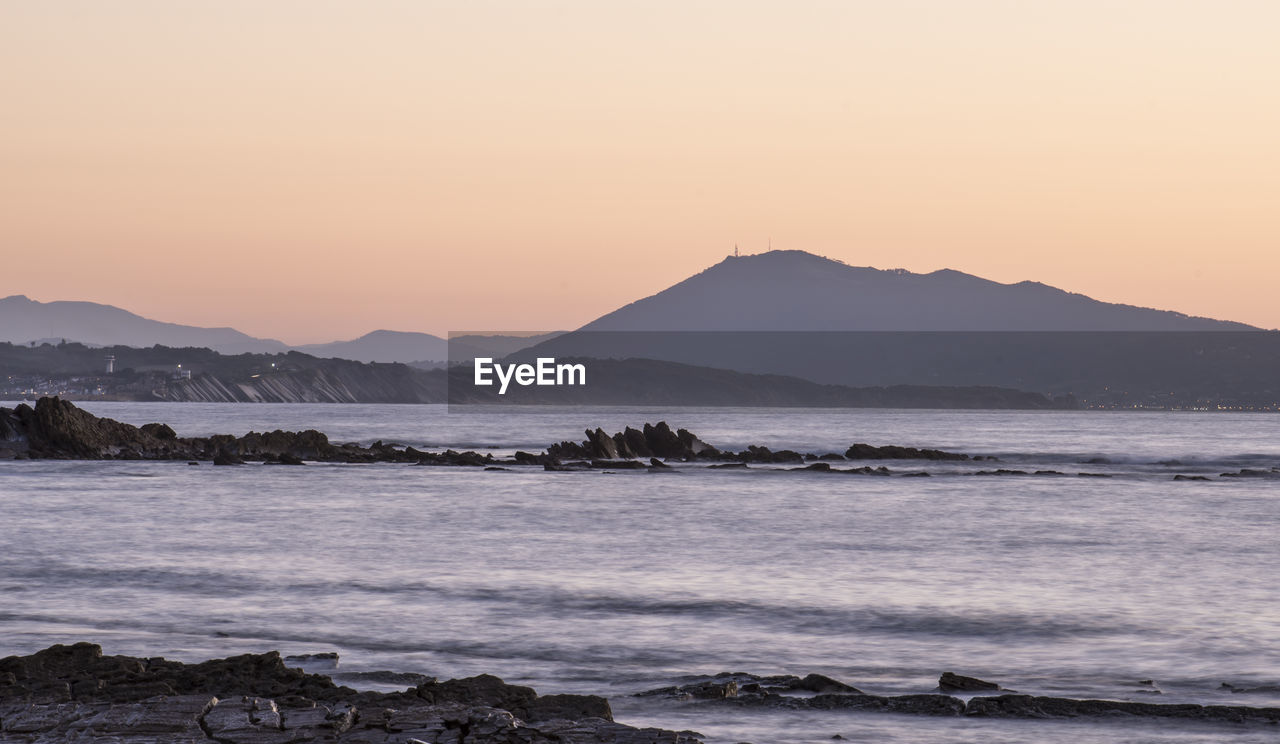 Scenic view of sea against clear sky during sunset