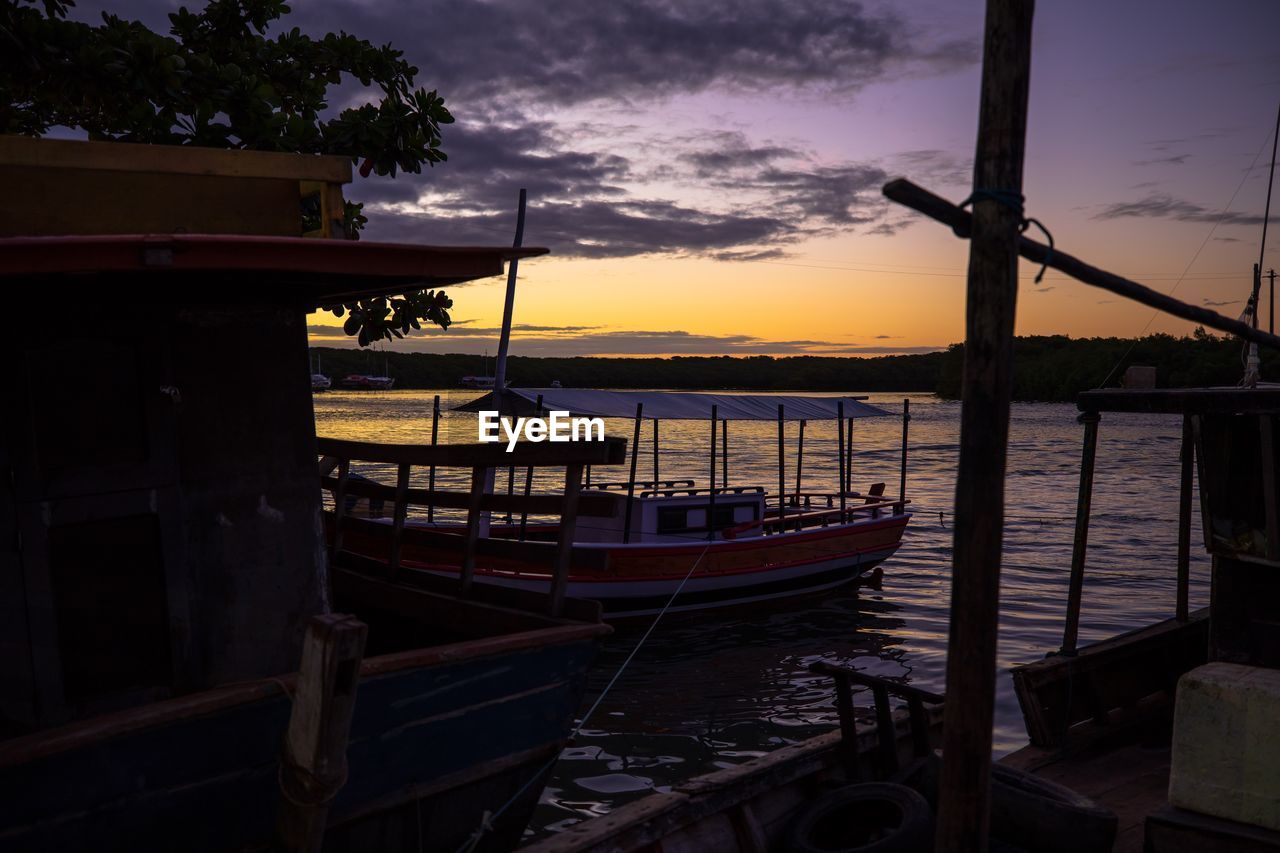 BOATS MOORED ON SEA AGAINST SKY DURING SUNSET