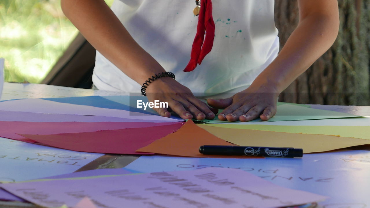 Midsection of man making art from colorful paper