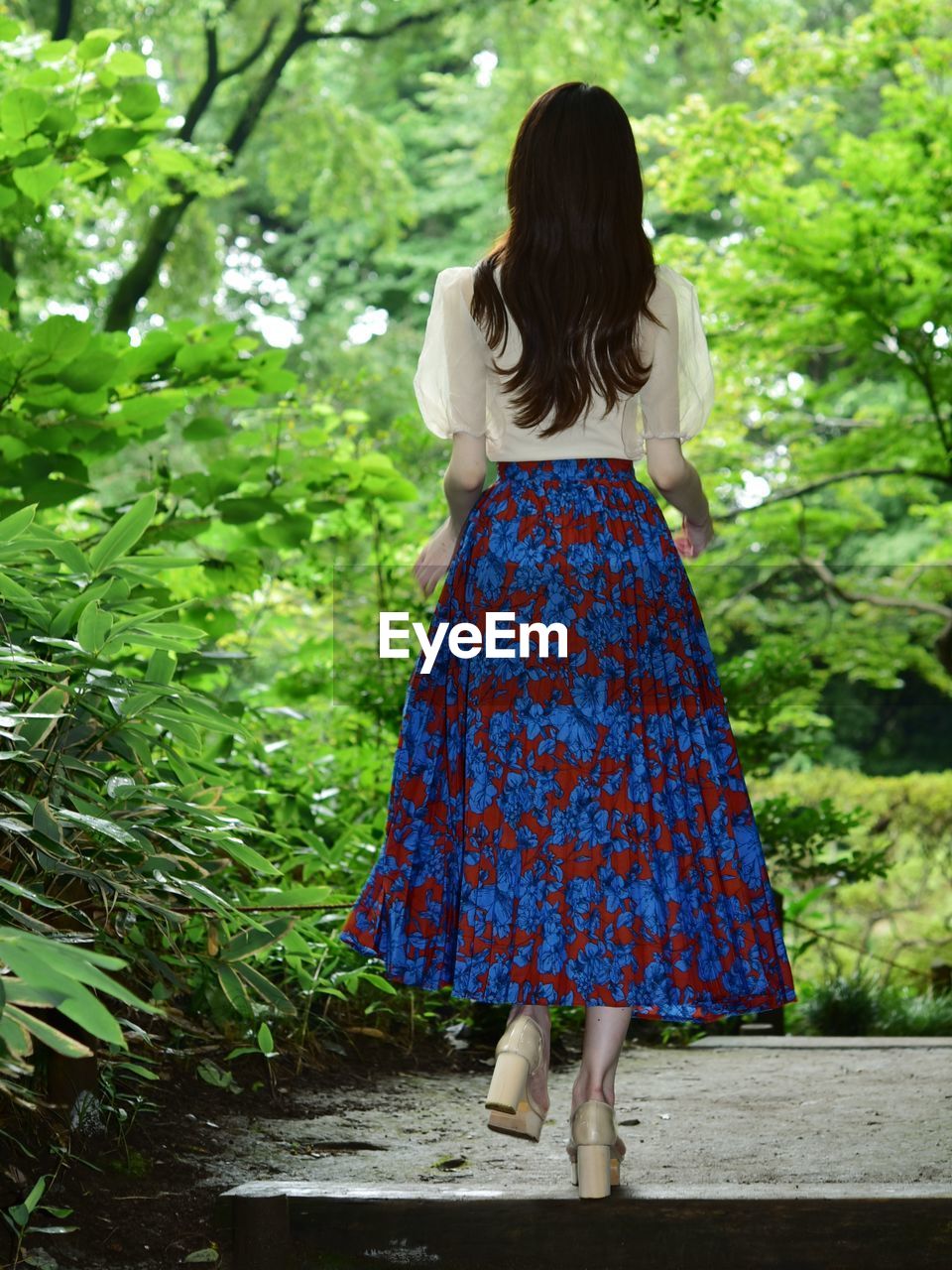 Rear view of woman standing against plants