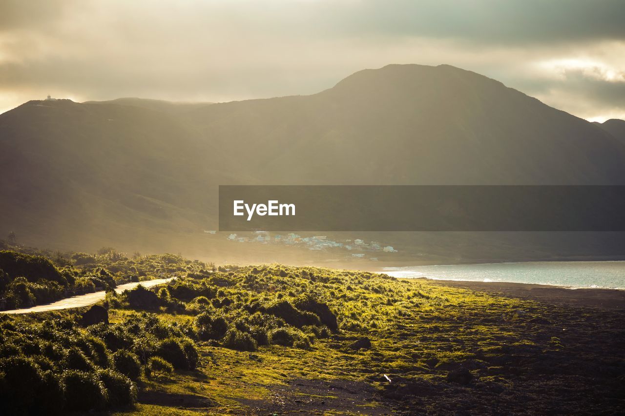 Scenic view of sea and mountains against sky