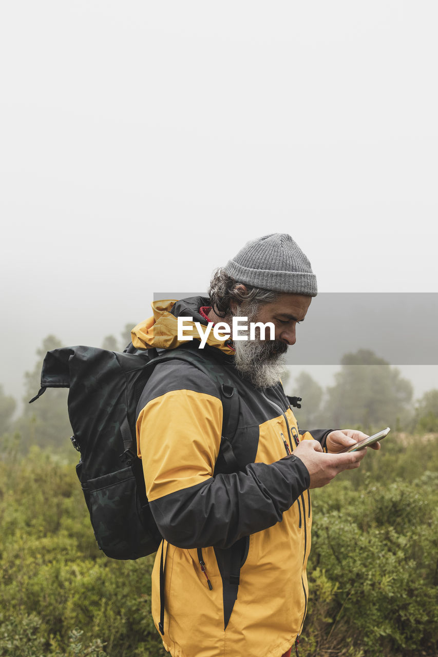 A man catches the signal on his mobile phone while looking for interesting places in the mountains