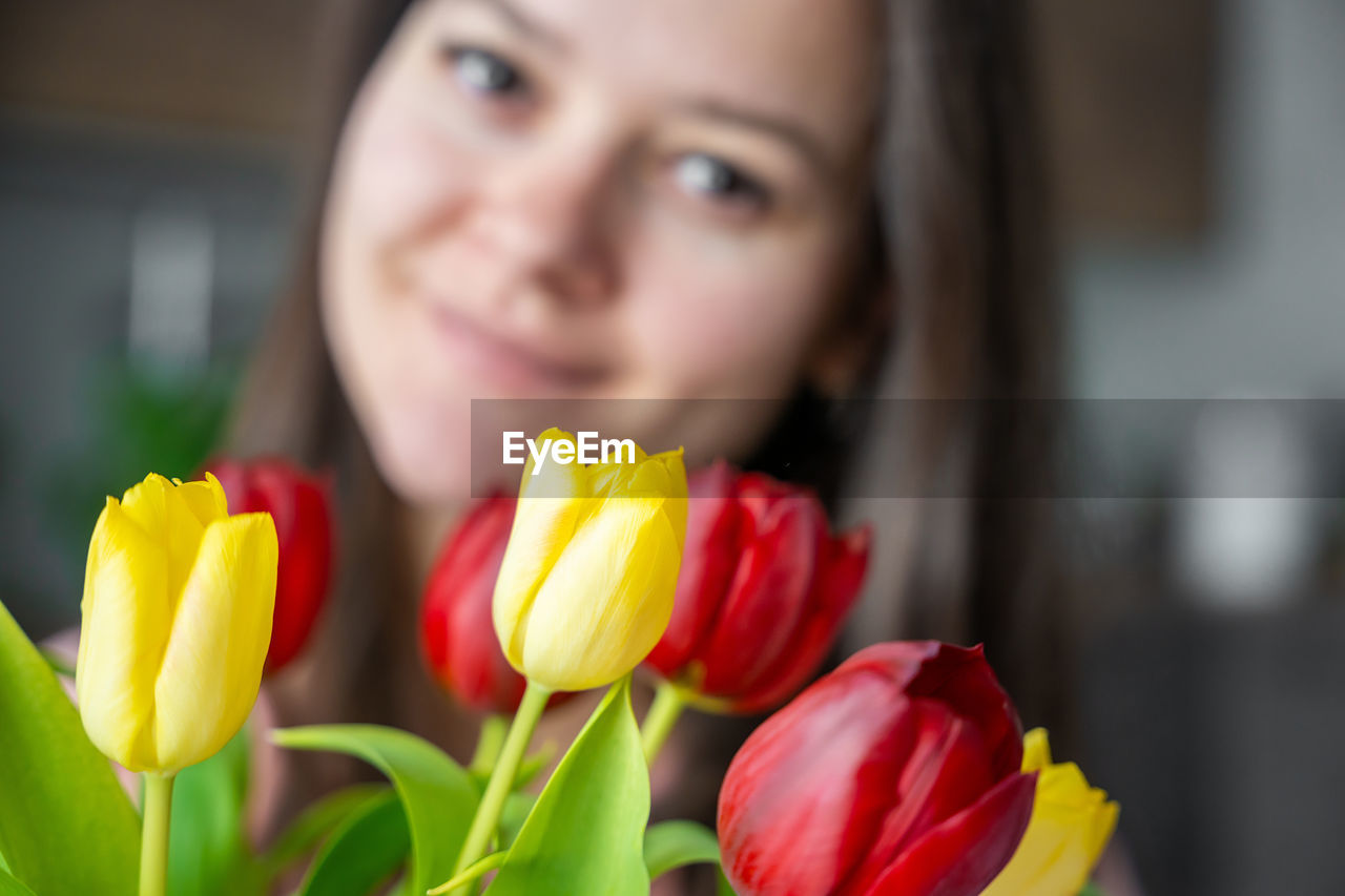 close-up of young woman with red rose flower