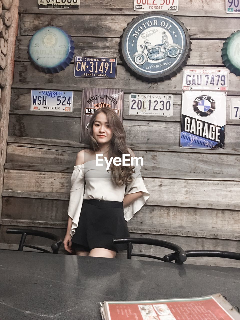 PORTRAIT OF HAPPY WOMAN STANDING AGAINST WALL