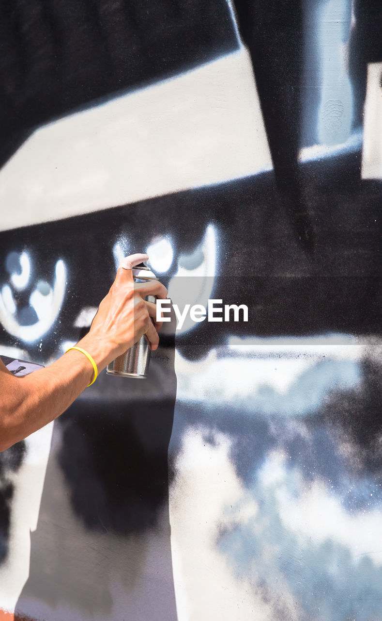 Man spraying paint on wall