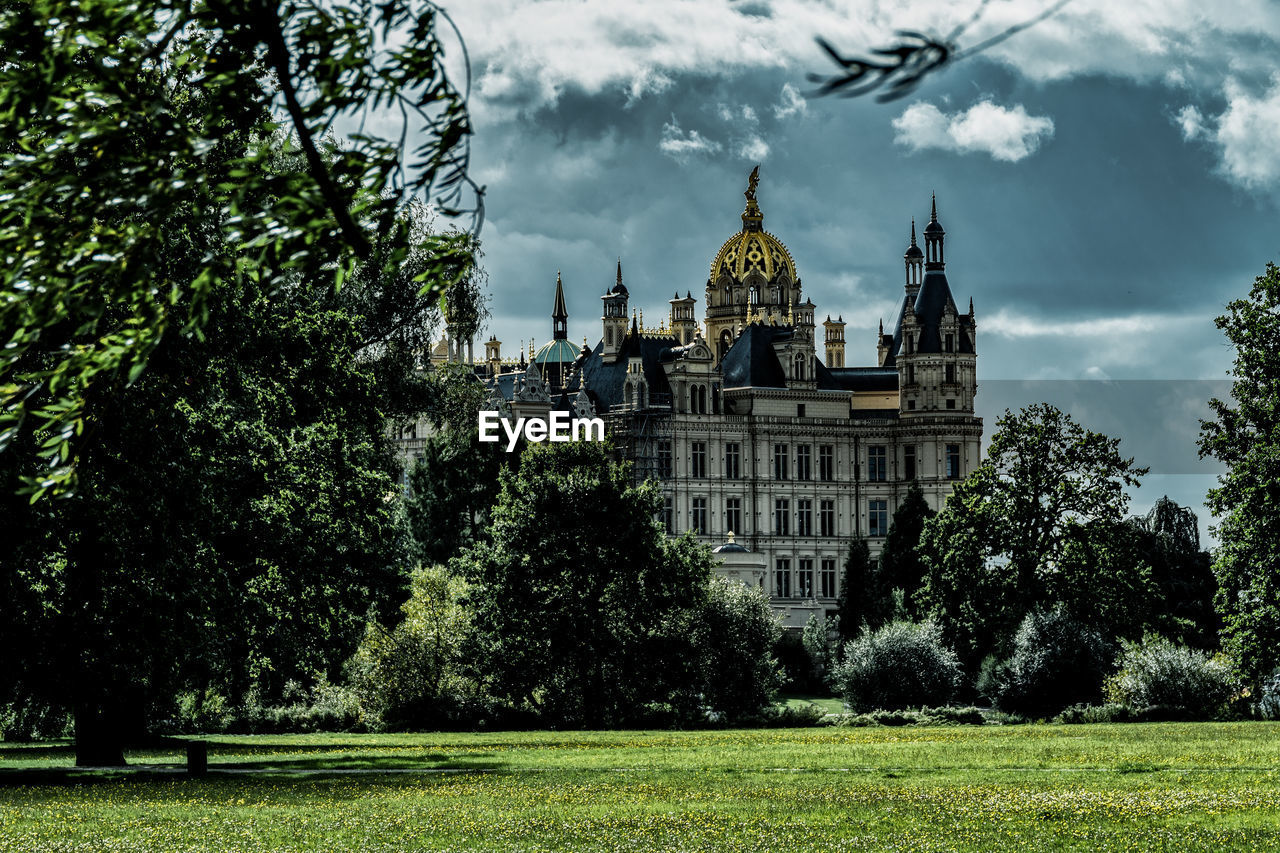 VIEW OF TREES AND BUILDING AGAINST SKY