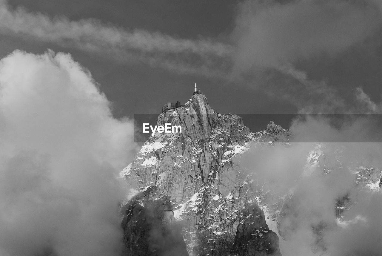 Low angle view of snow on mountain against cloudy sky