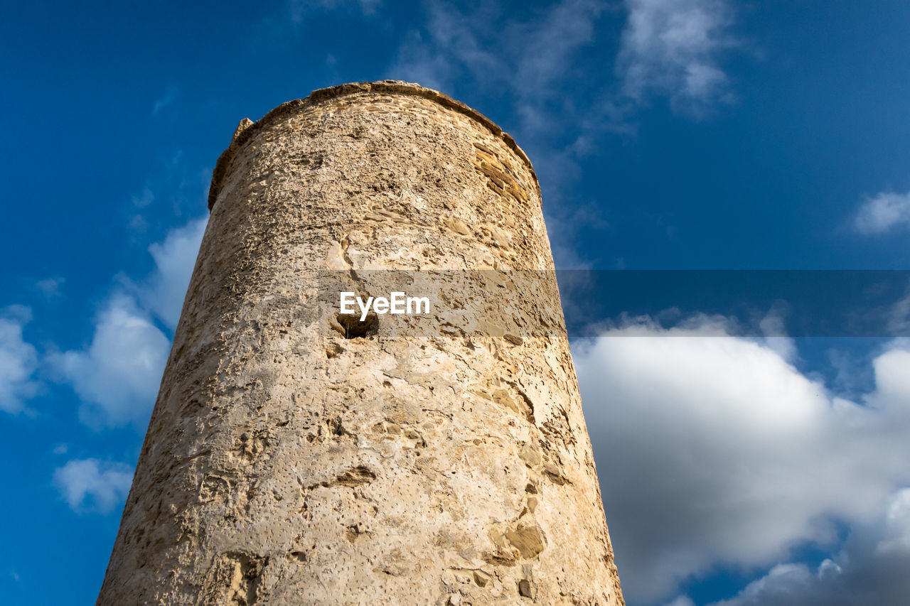 Low angle view of tower against cloudy sky