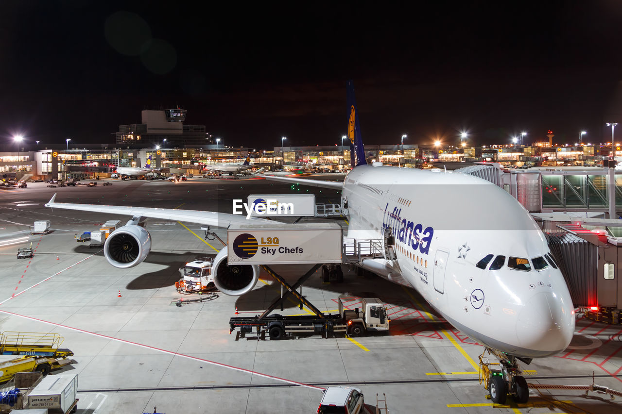 HIGH ANGLE VIEW OF AIRPLANE AT AIRPORT RUNWAY AT NIGHT