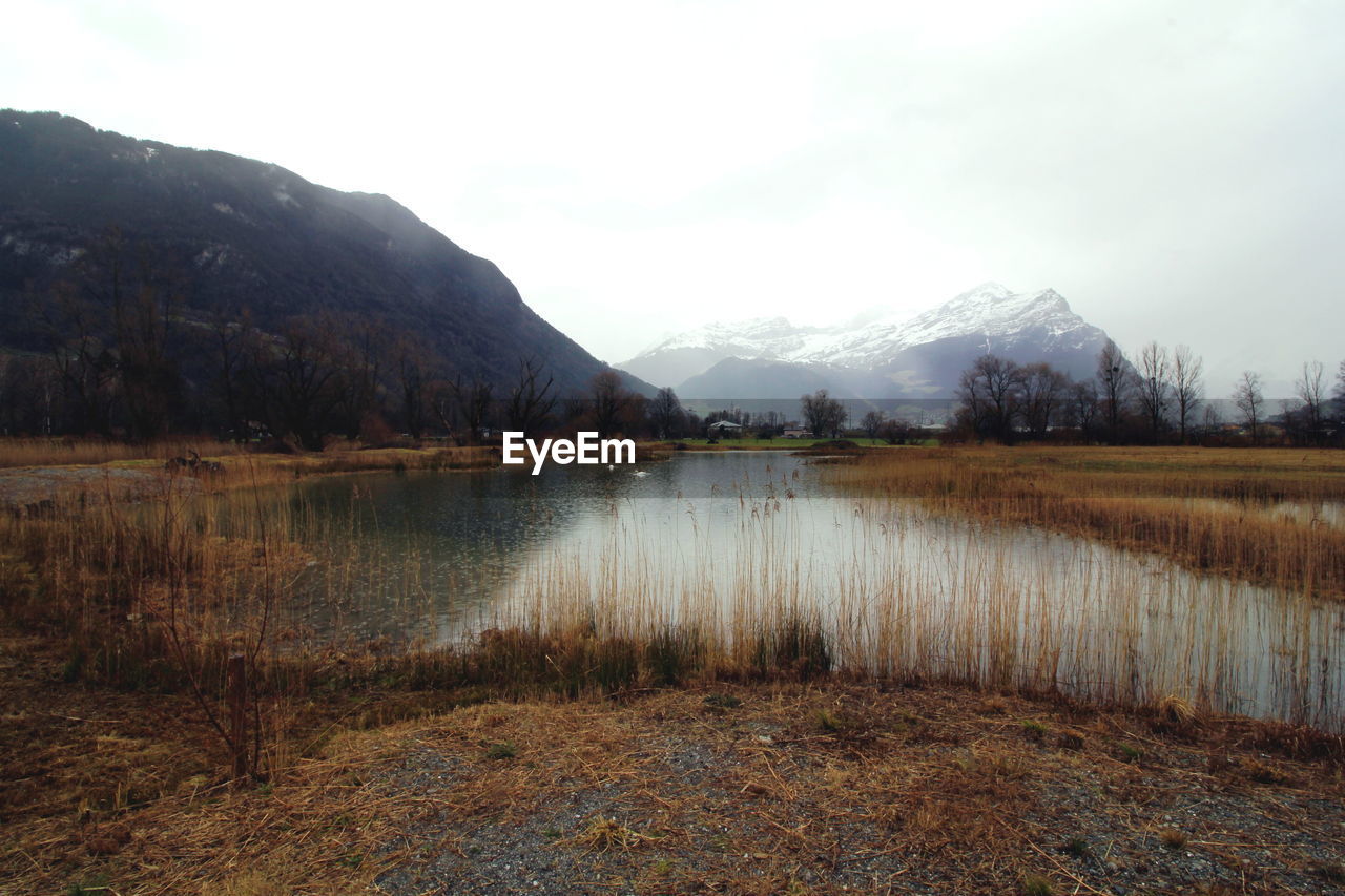 Scenic view of lake and mountains against sky