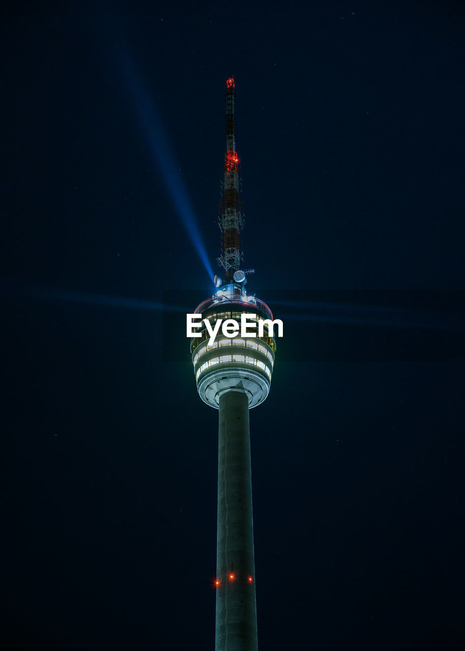 Stuttgart television tower against night sky with stars and light beams