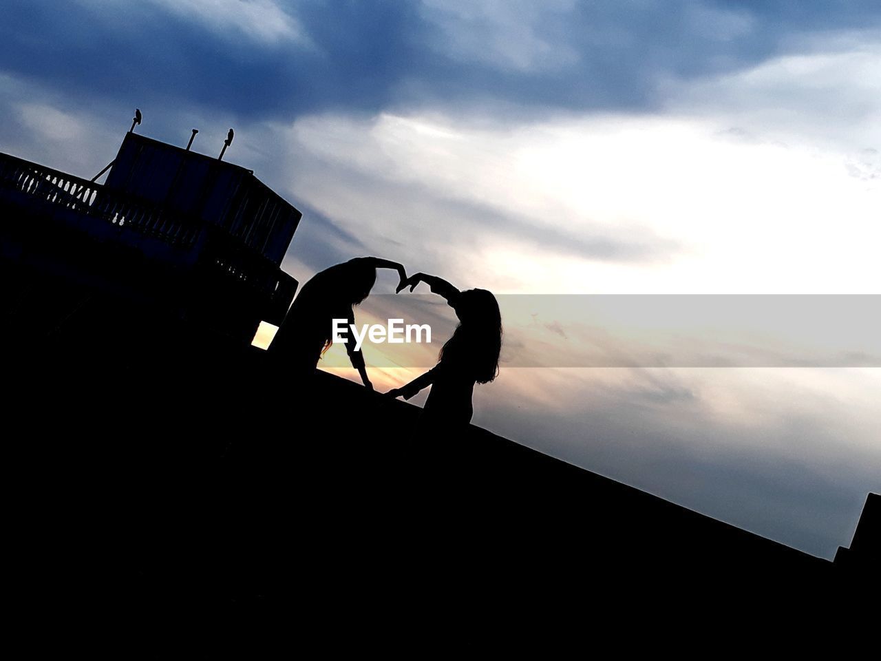 Low angle view of silhouette built structure against sky