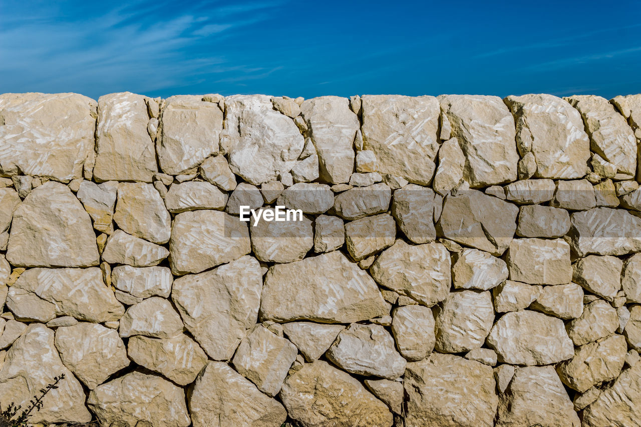 View of stone wall against blue sky