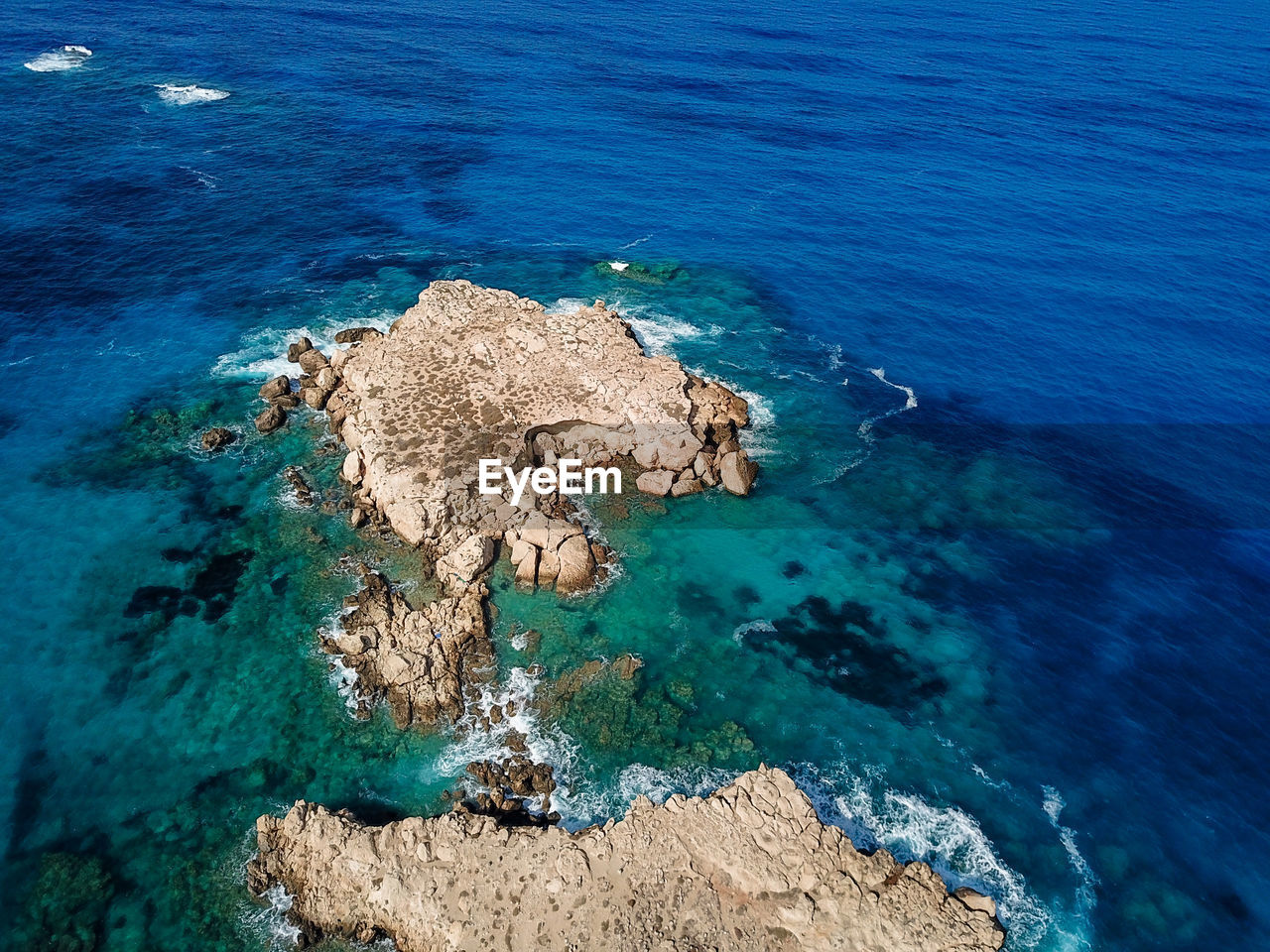 HIGH ANGLE VIEW OF ROCK FORMATIONS AT SHORE