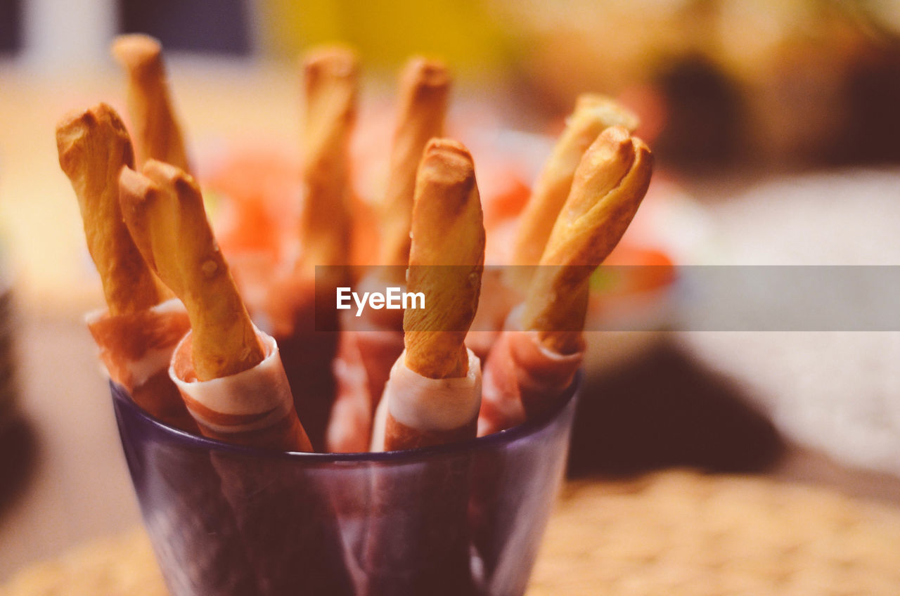 Close-up of breadsticks in container on table