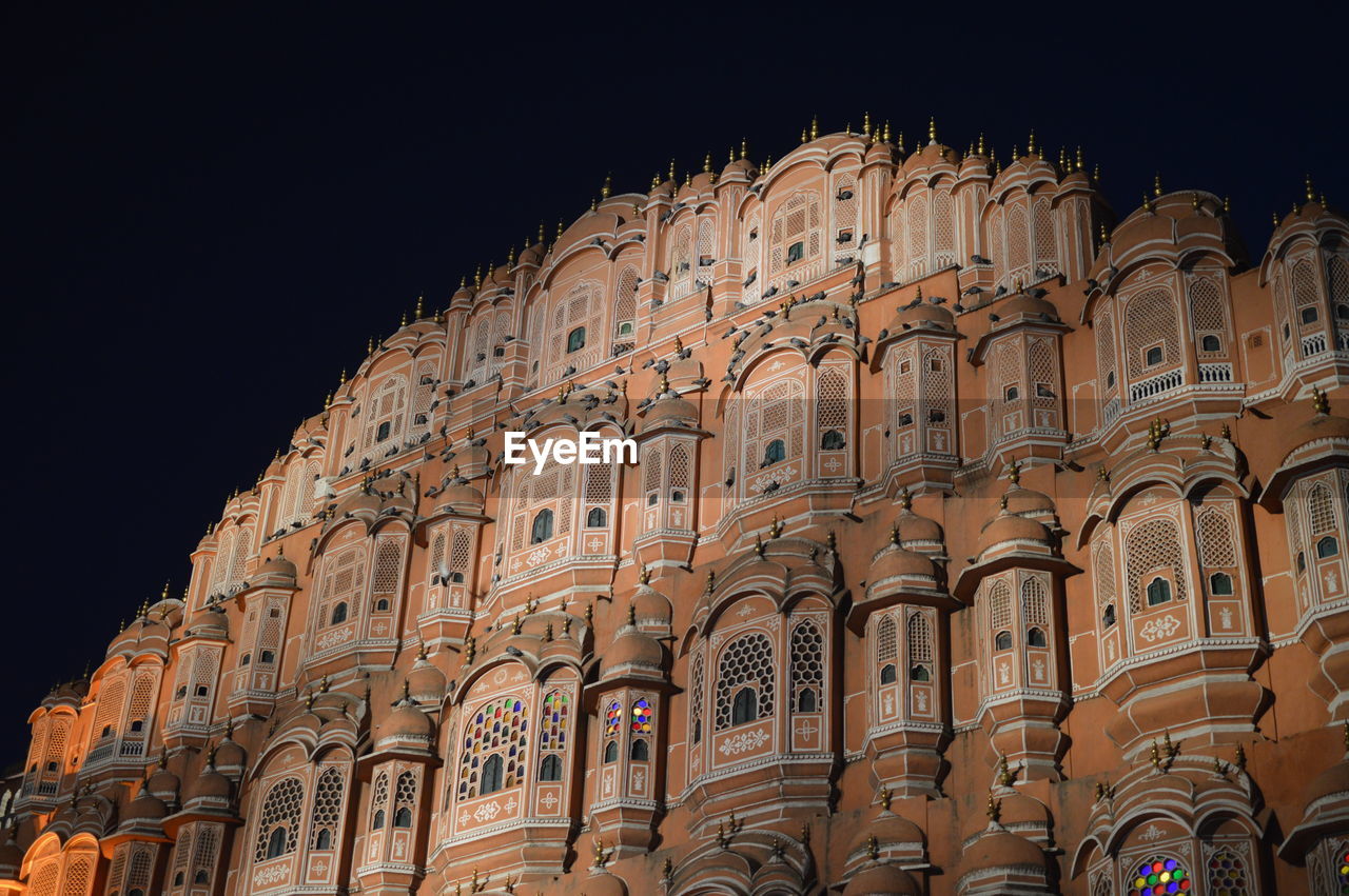 Low angle view of building against clear sky at night