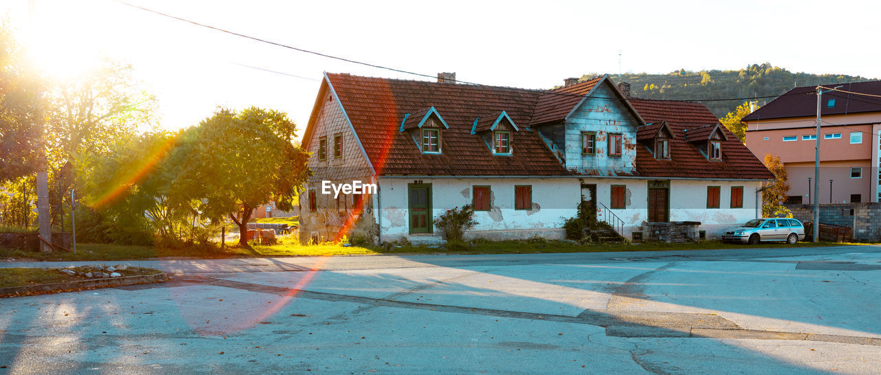 architecture, building exterior, built structure, building, house, town, nature, sky, residential district, residential area, city, street, estate, neighbourhood, sunlight, tree, road, plant, no people, outdoors, water, home, day, suburb, multi colored, travel destinations, mansion, sunny