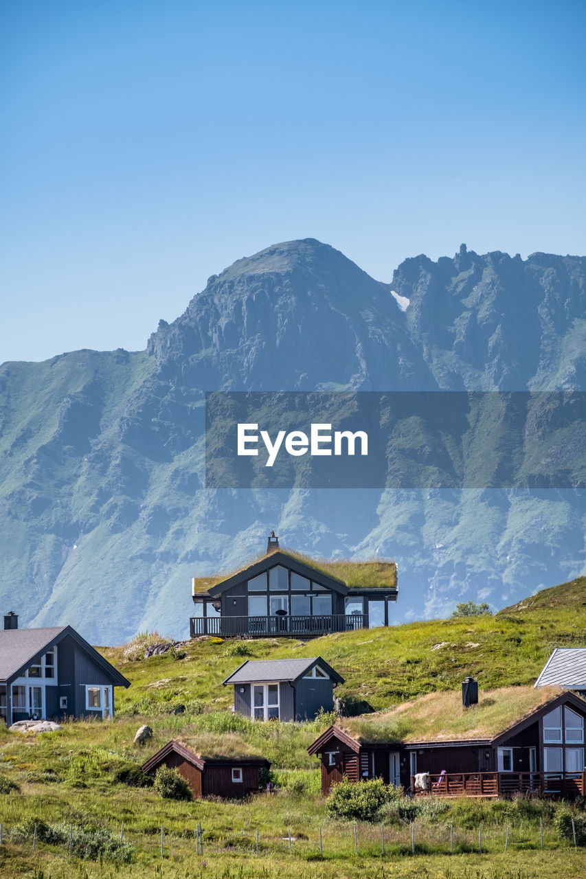 Houses on mountain against blue sky