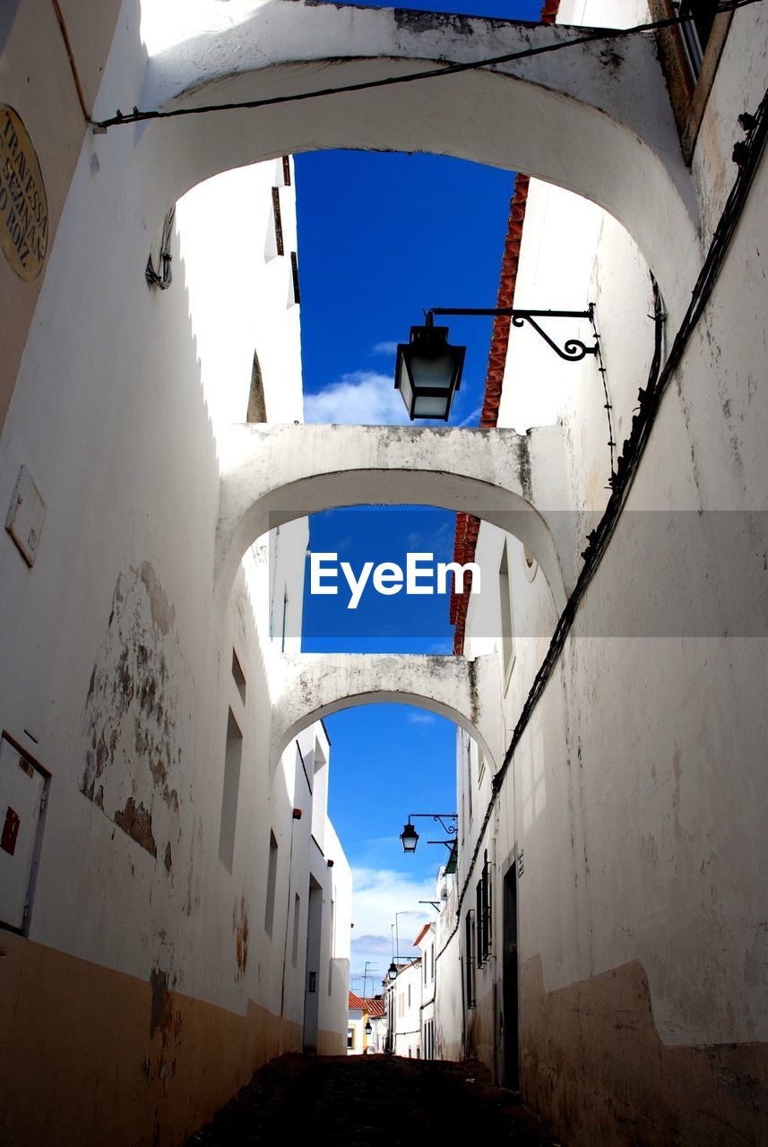 Wall lanterns on narrow alley along houses