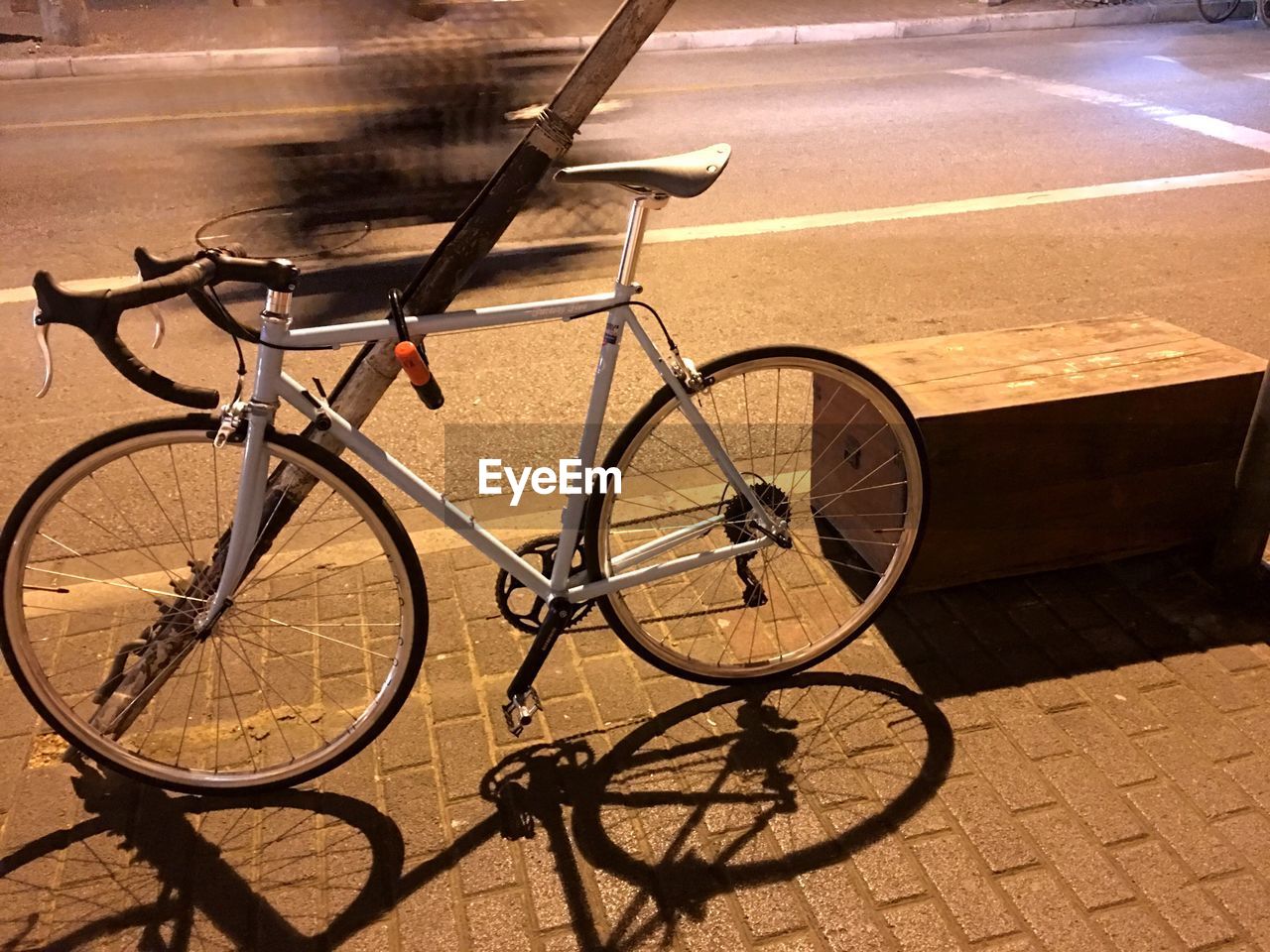 High angle view of bicycle parked on sidewalk at night