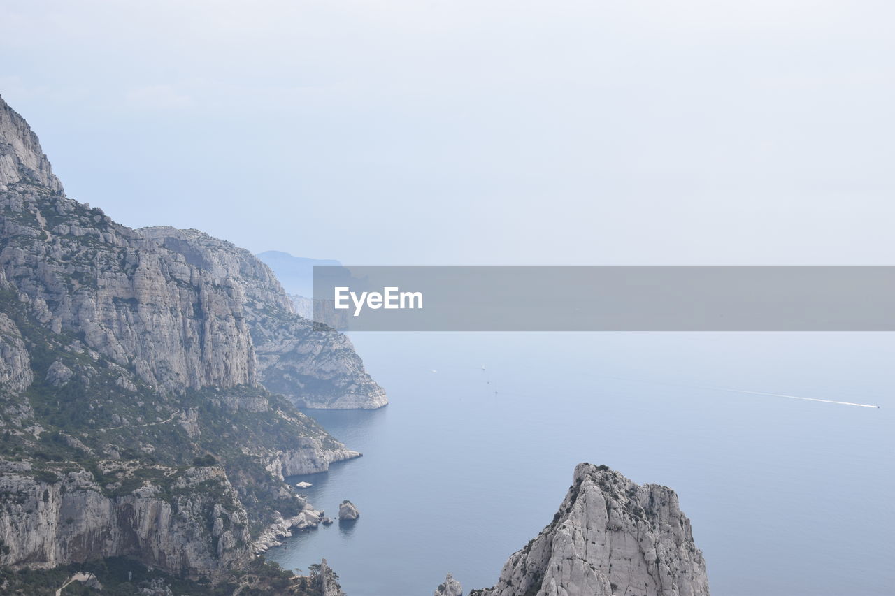 Scenic view of sea and mountains against sky