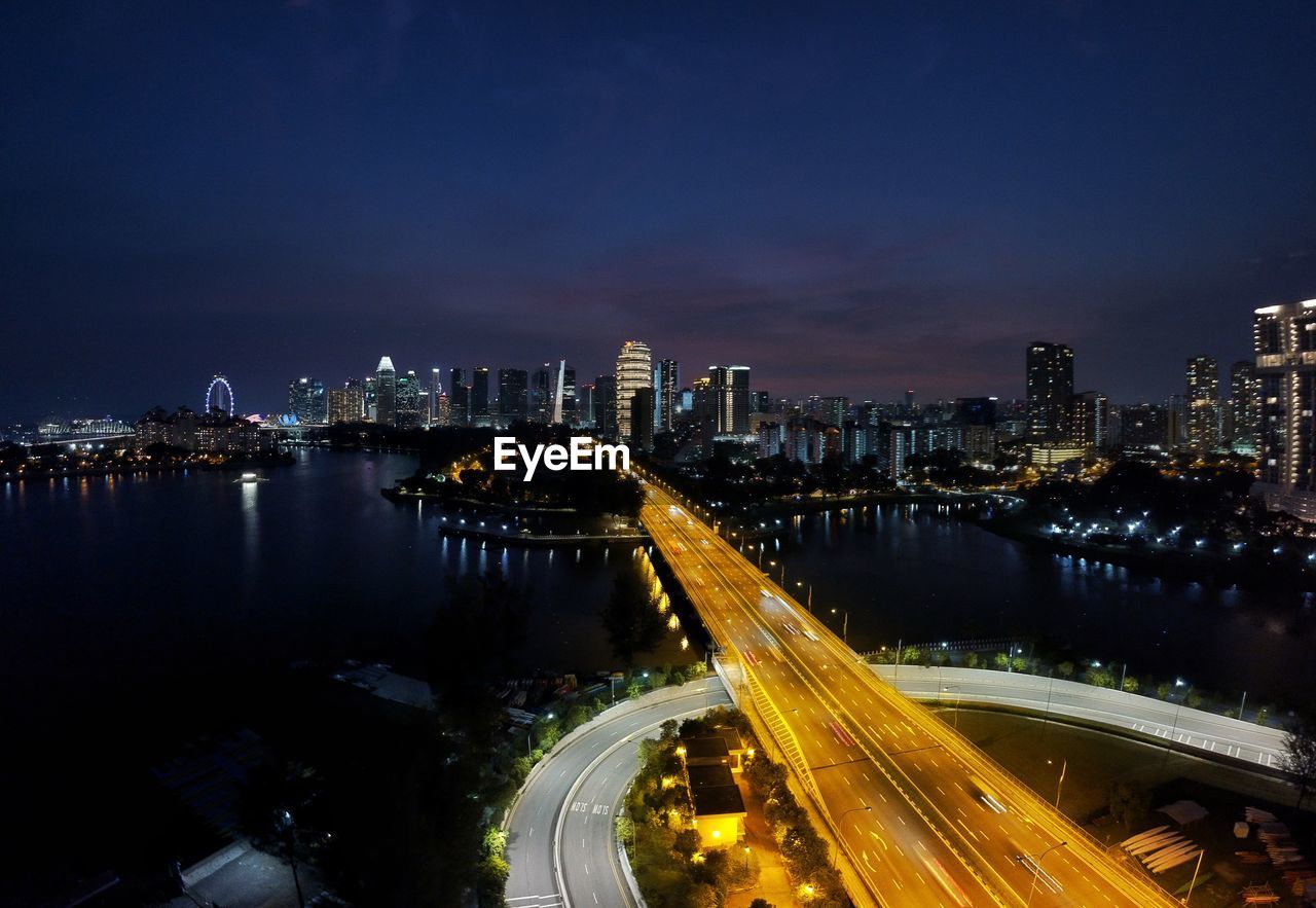 High angle view of illuminated street amidst buildings at night