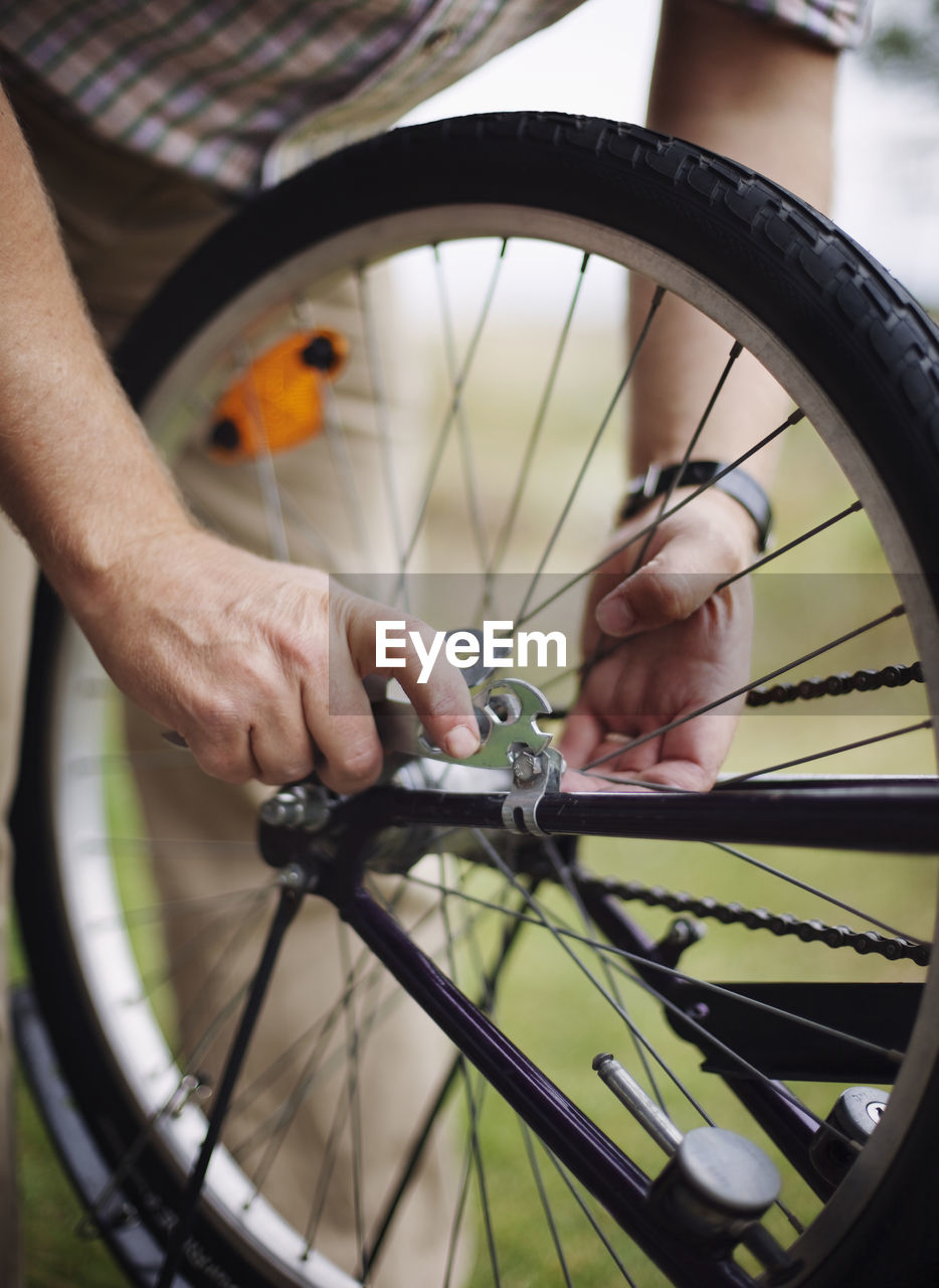 Close-up of hands repairing bicycle wheels