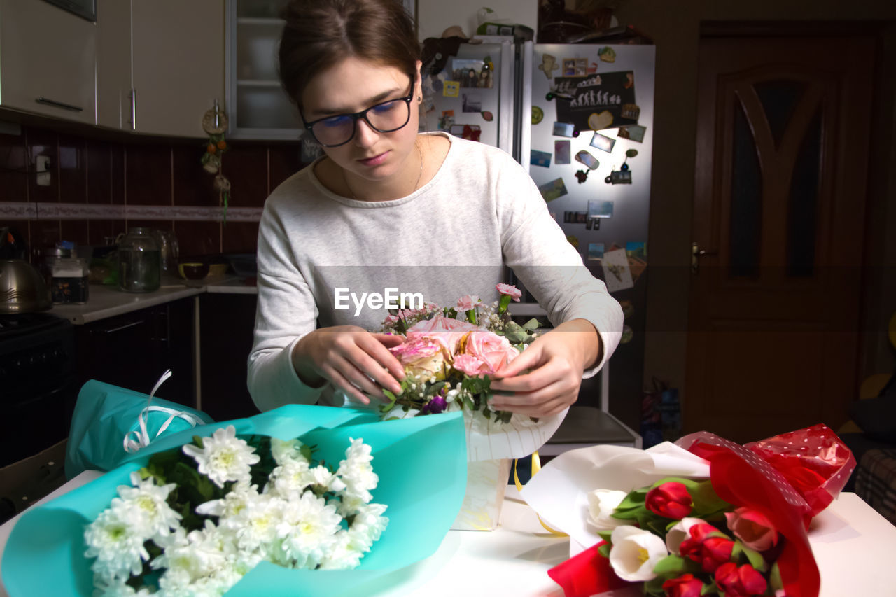 Flowers background. florist create beautiful bouquets at night. small business. female florist in 