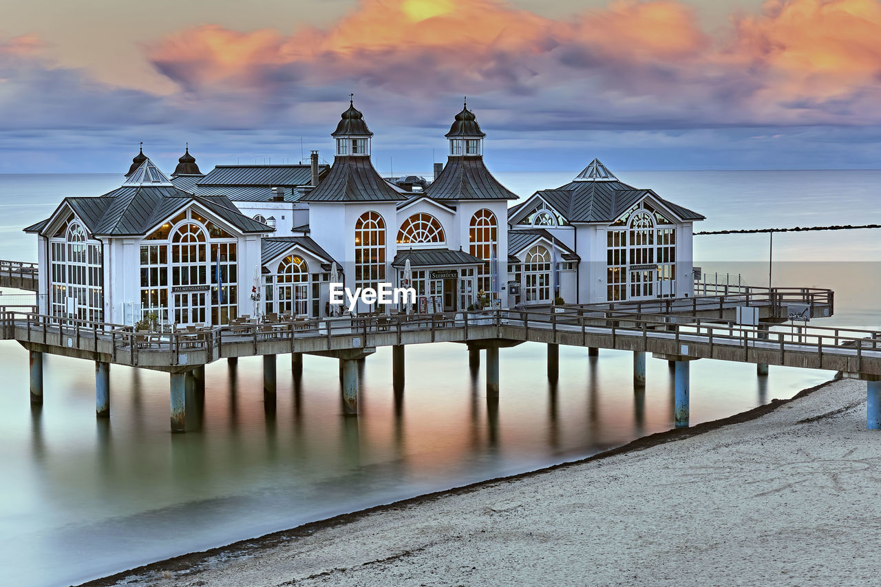 VIEW OF PIER ON SEA AGAINST BUILDINGS