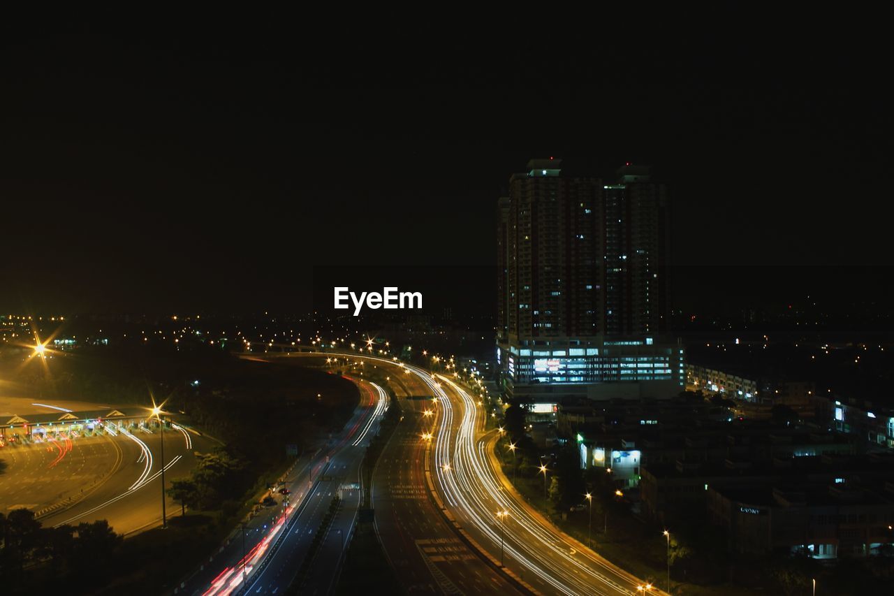 High angle view of illuminated street by building at night