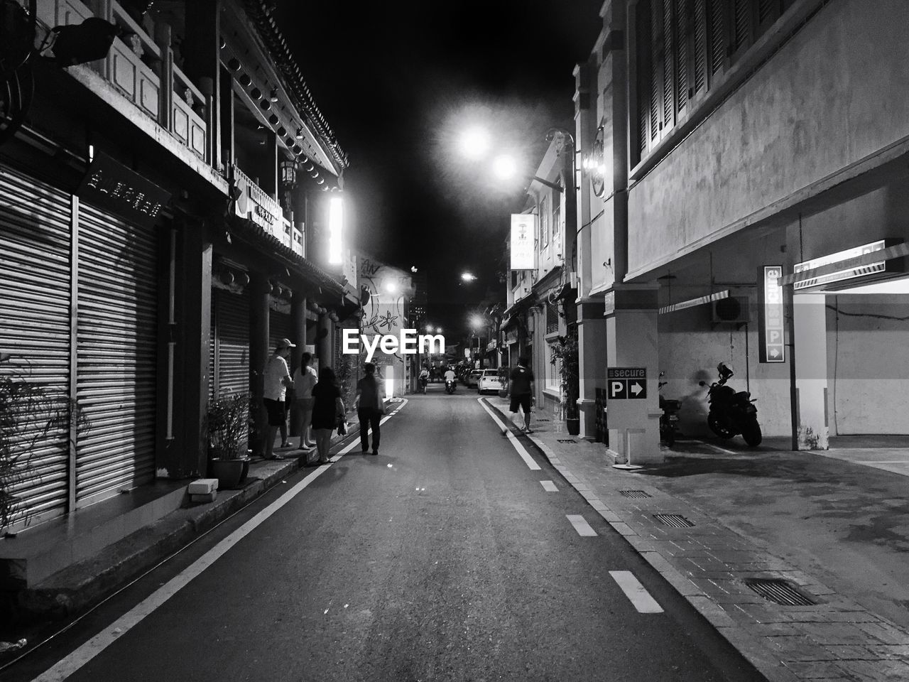 STREET AMIDST BUILDINGS IN CITY AT NIGHT