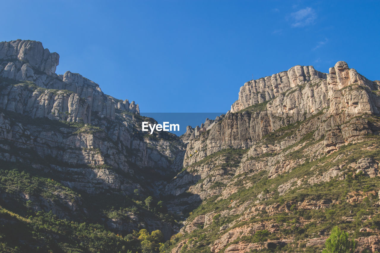 Scenic view of mountains against blue sky