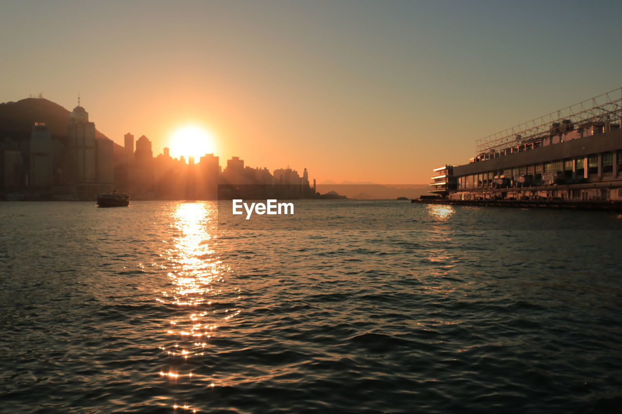 View of city at waterfront during sunset