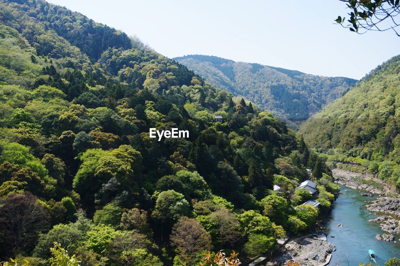 HIGH ANGLE VIEW OF RIVER AMIDST TREES AND MOUNTAINS AGAINST SKY