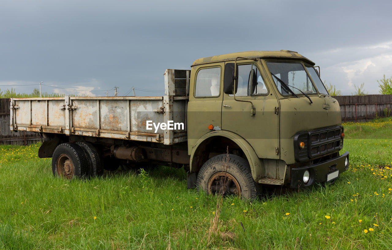 abandoned car on field against sky