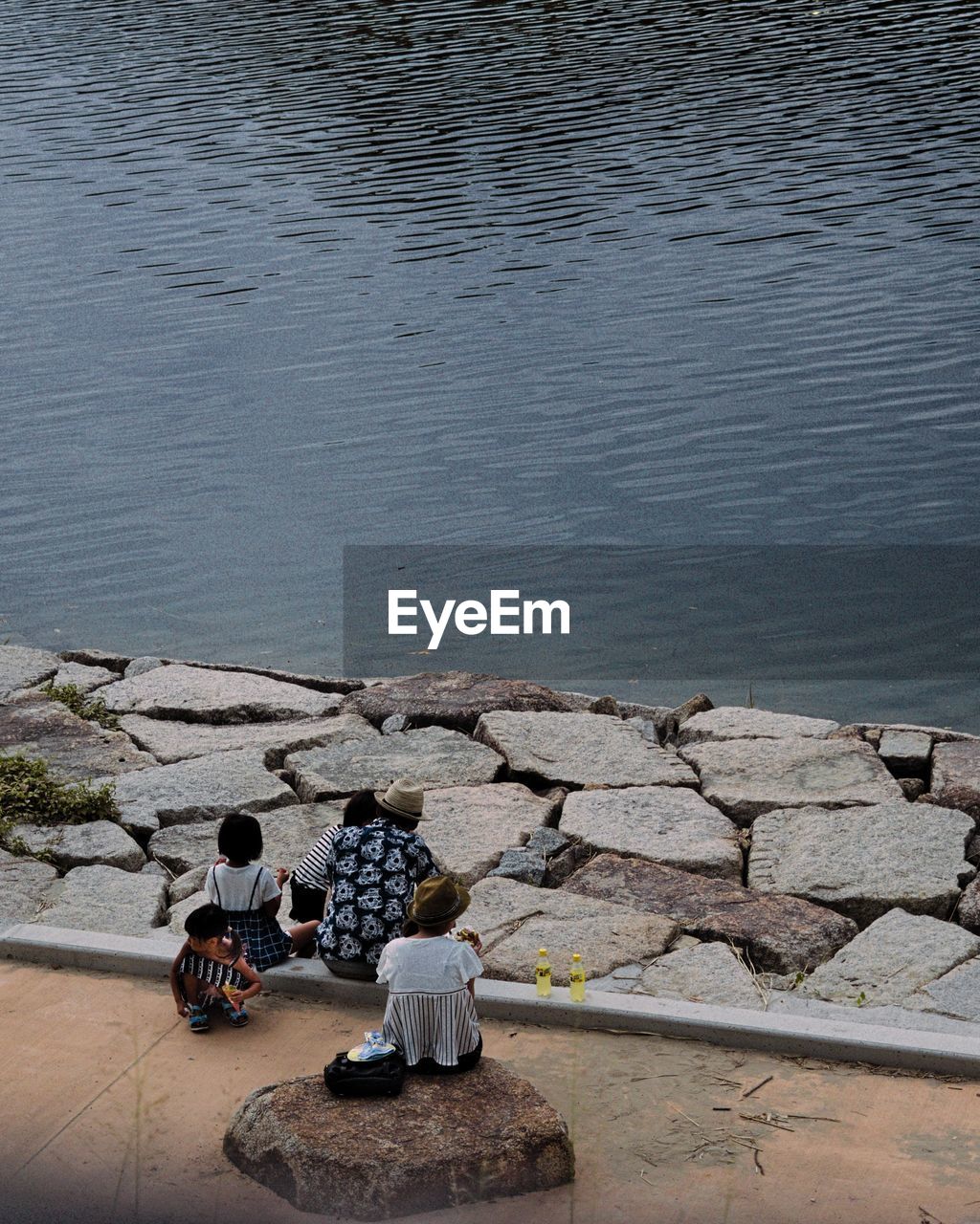 HIGH ANGLE VIEW OF PEOPLE SITTING ON ROCKS