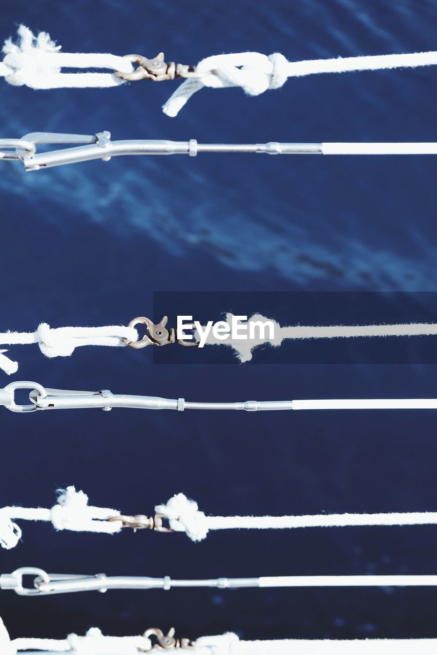 High angle view of ropes tied to hook against sea