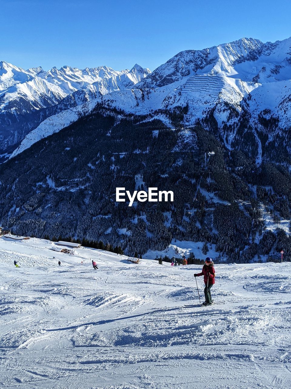 PERSON SKIING ON SNOWCAPPED MOUNTAINS AGAINST SKY