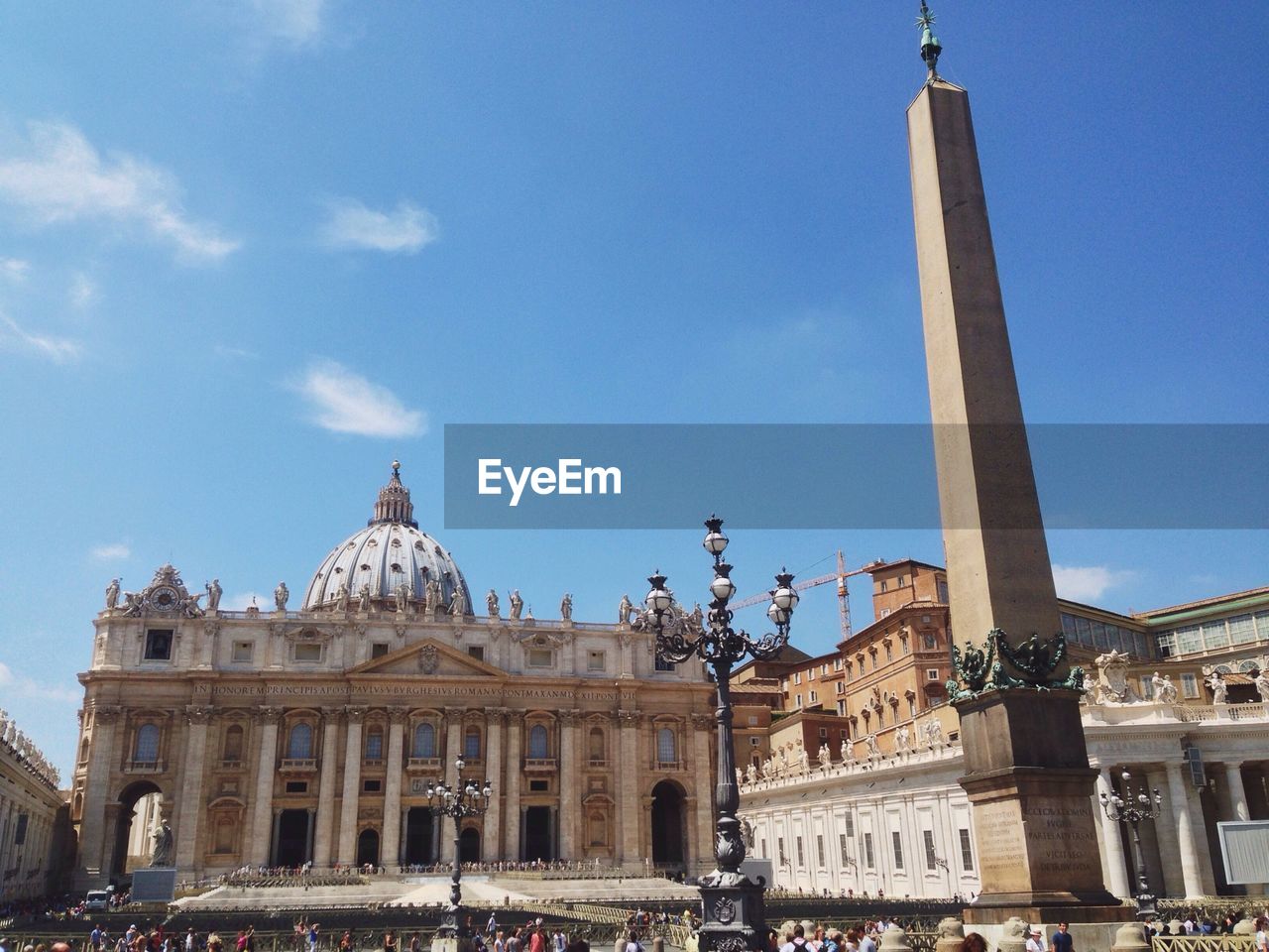Low angle view of saint peters basilica and memorial column against blue sky
