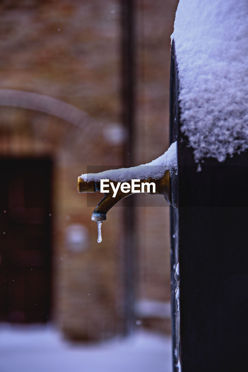 Close-up of frozen faucet during snow