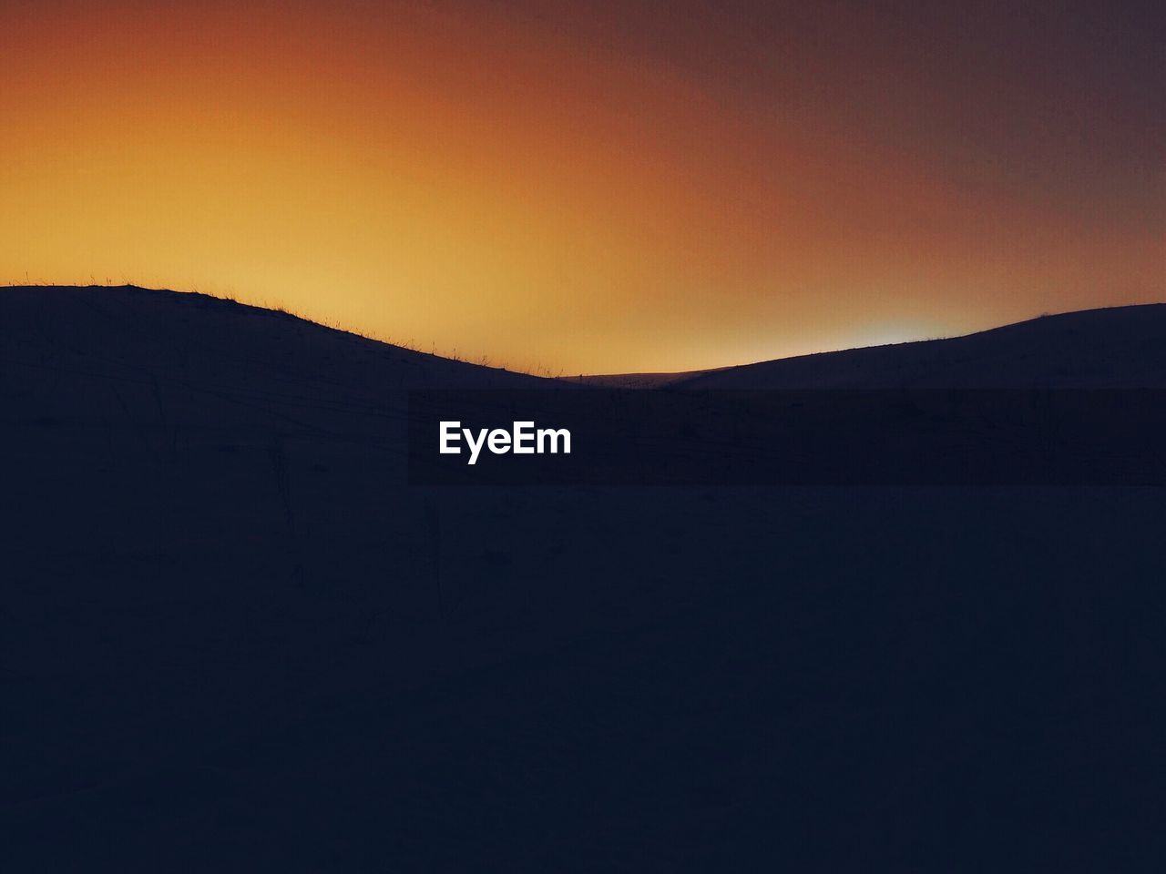 SCENIC VIEW OF SILHOUETTE MOUNTAINS AGAINST SKY AT DUSK